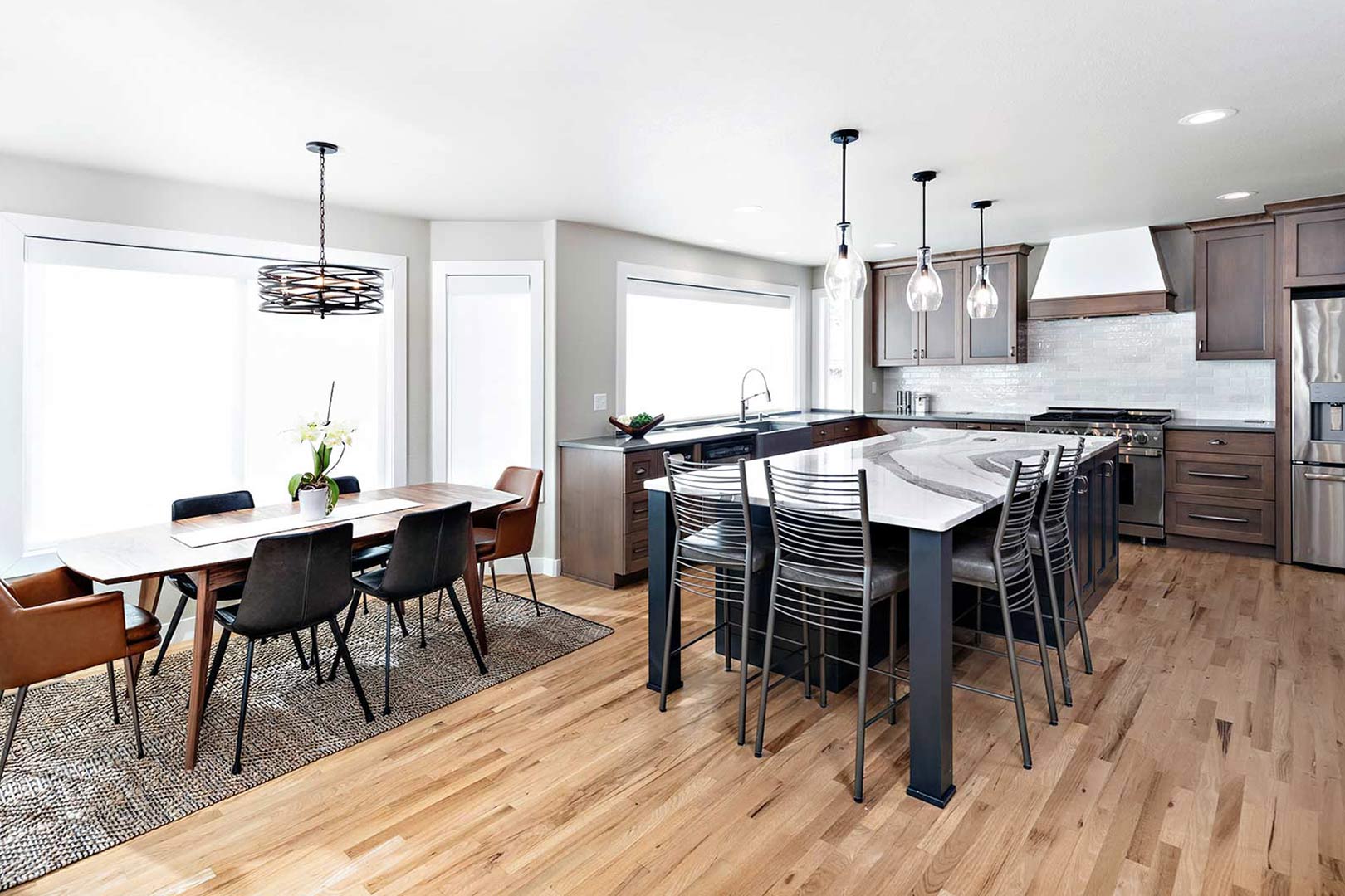 Transitional farmhouse kitchen wide angle view showing the oversized island with a dining nook in Fort Collins Colorado