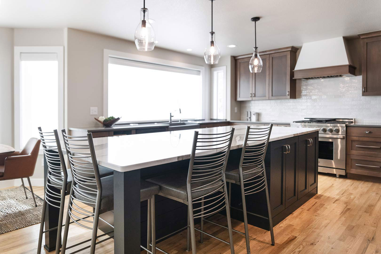 Detailed view of the modern steel barstools nested in the grand island of a kitchen renovation in Fort Collins, Colorad