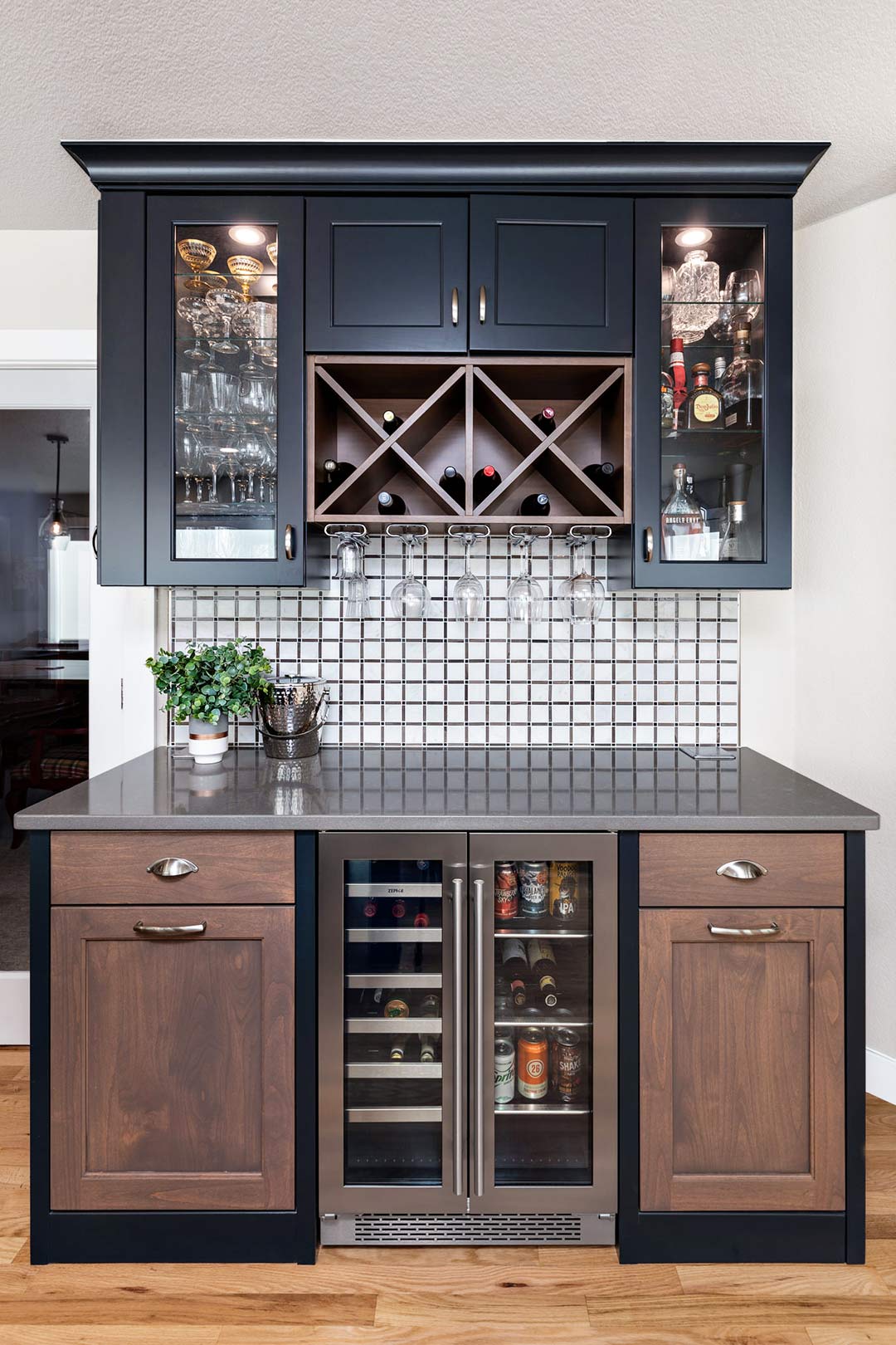 Built-in modern bar with a custom tiled backsplash and two toned cabinets 