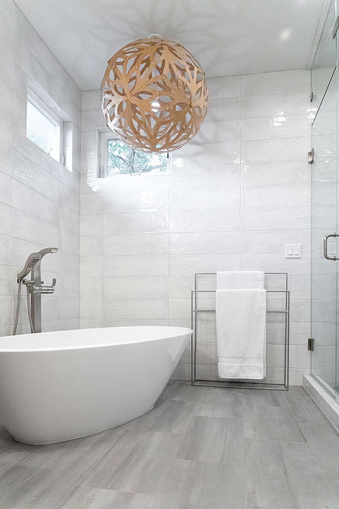 View of the freestanding tub with a modern chandelier-like globe light fixture overhead