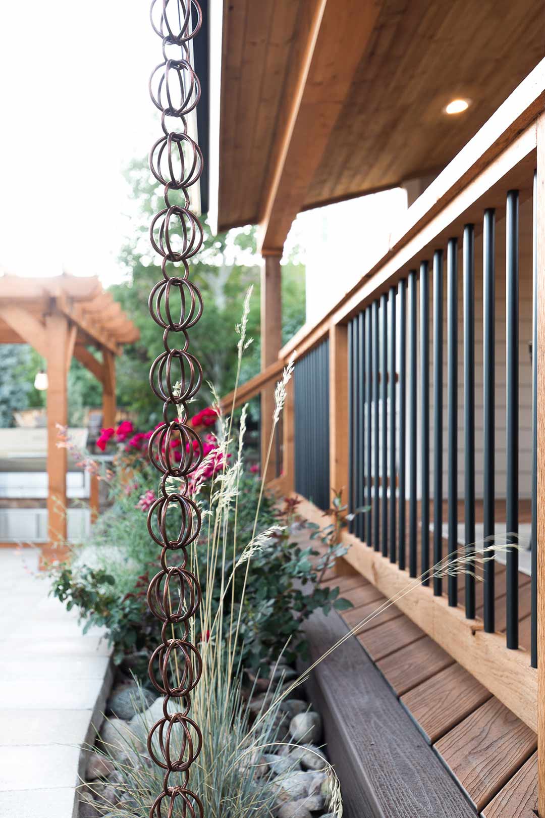 Custom copper rain chains accent the modern patio railing installed by Freestone Design-Build in Fort Collins Colorado