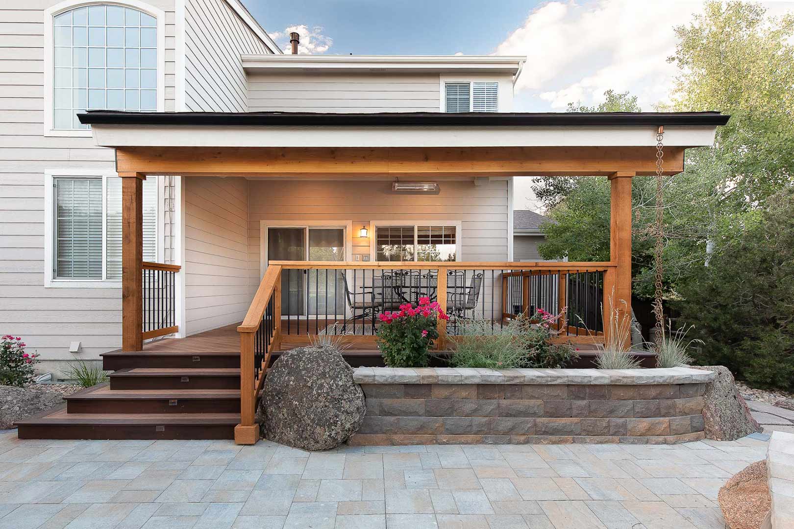 A custom covered deck with a stacked stone rock planter bed