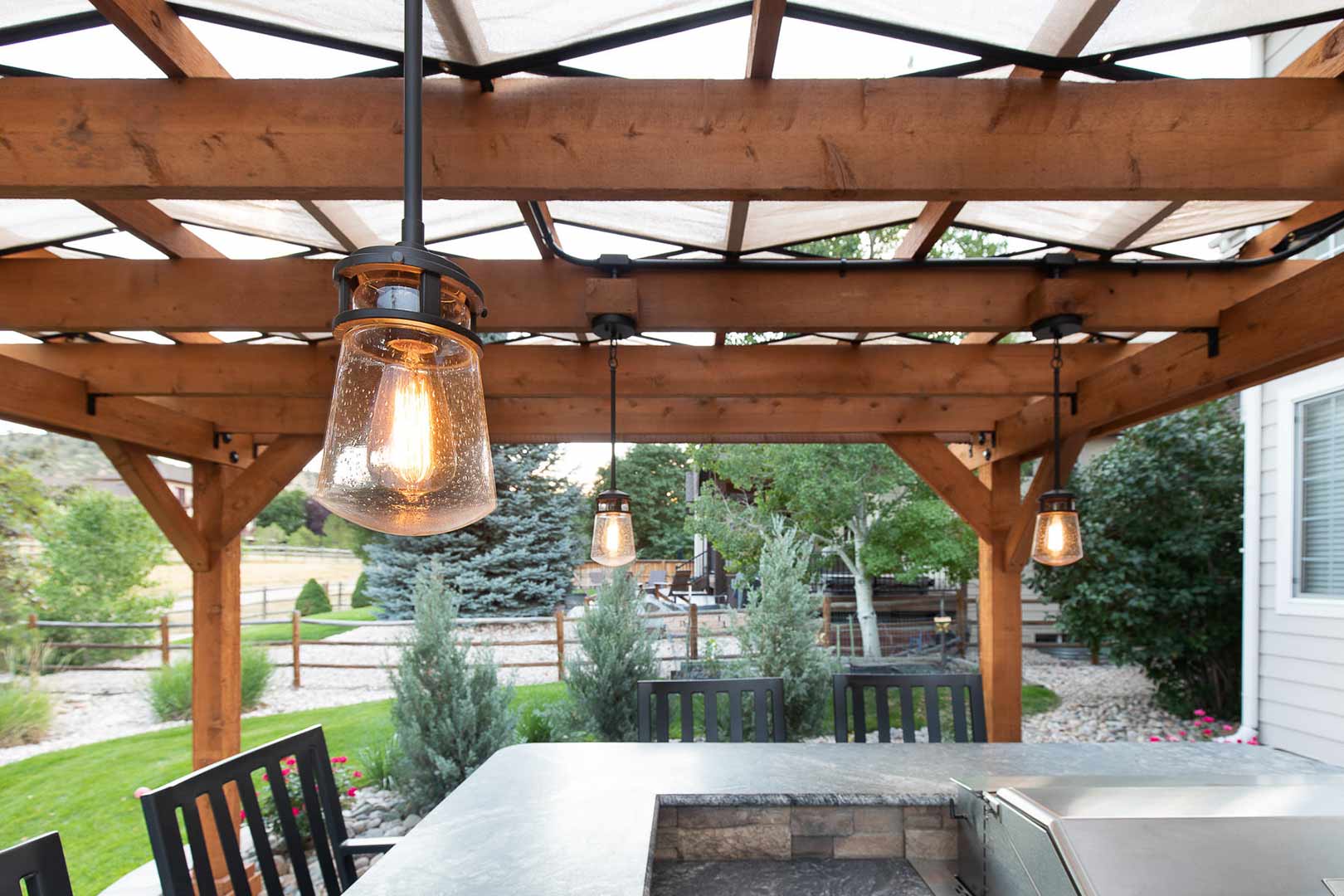 Modern light fixtures hanging off the pergola installed by Freestone Design-Build