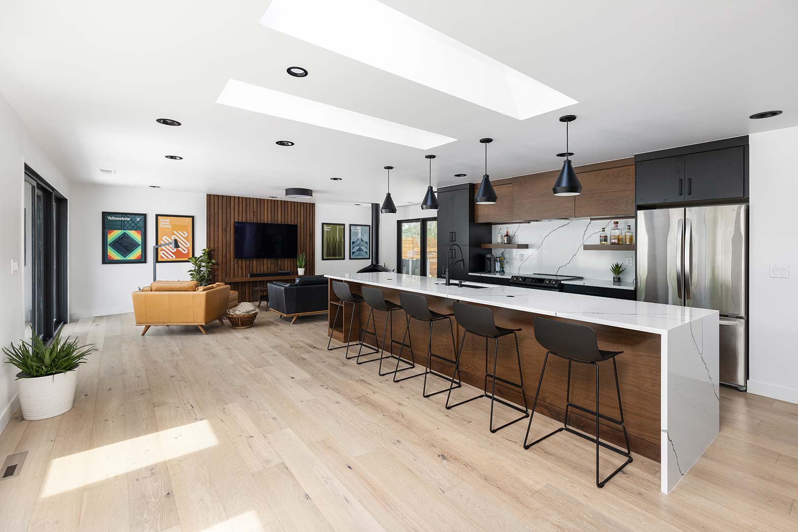 Large waterfall coutertop island with 5 barstools is the feature of this mid-century modern remodel and kitchen renovation in Fort Collins Colorado