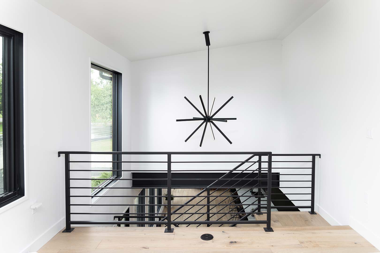 Additional view of the loft area showing the modern powder coated stair rail and a oversized modern light fixture 