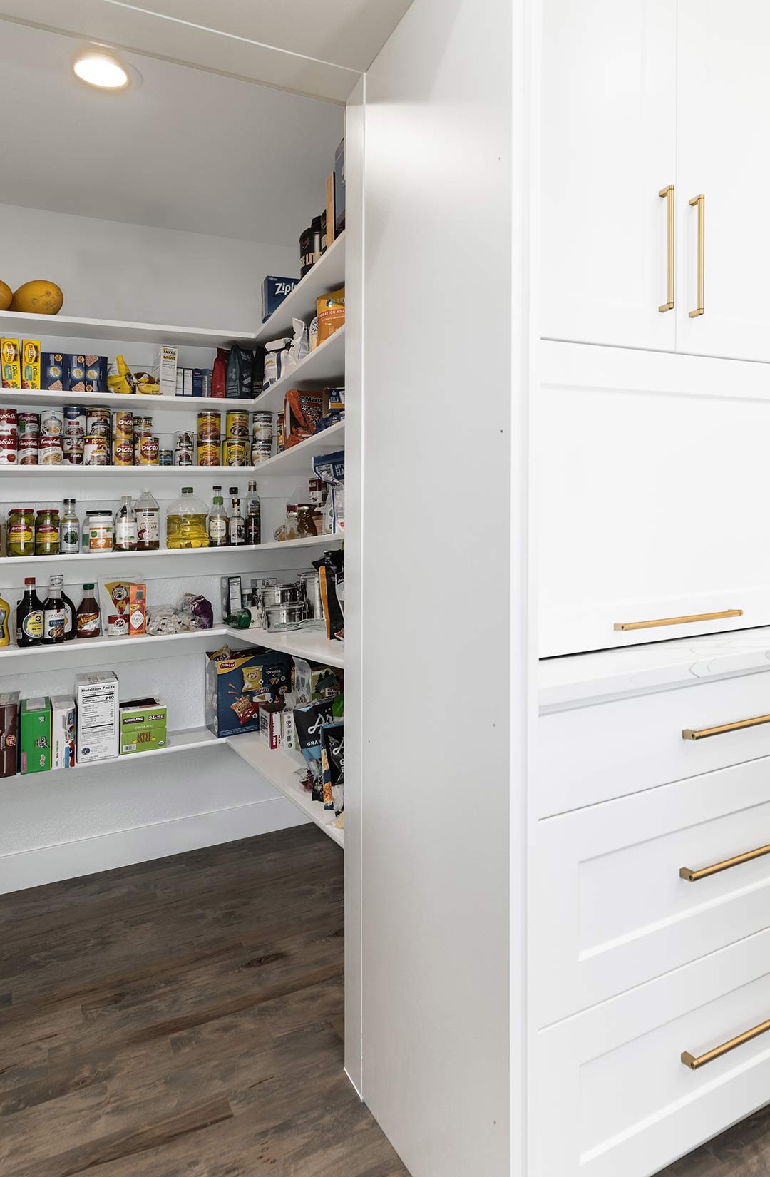 A hidden pantry in this modern transitional kitchen shows a glimpse of the family's food storage