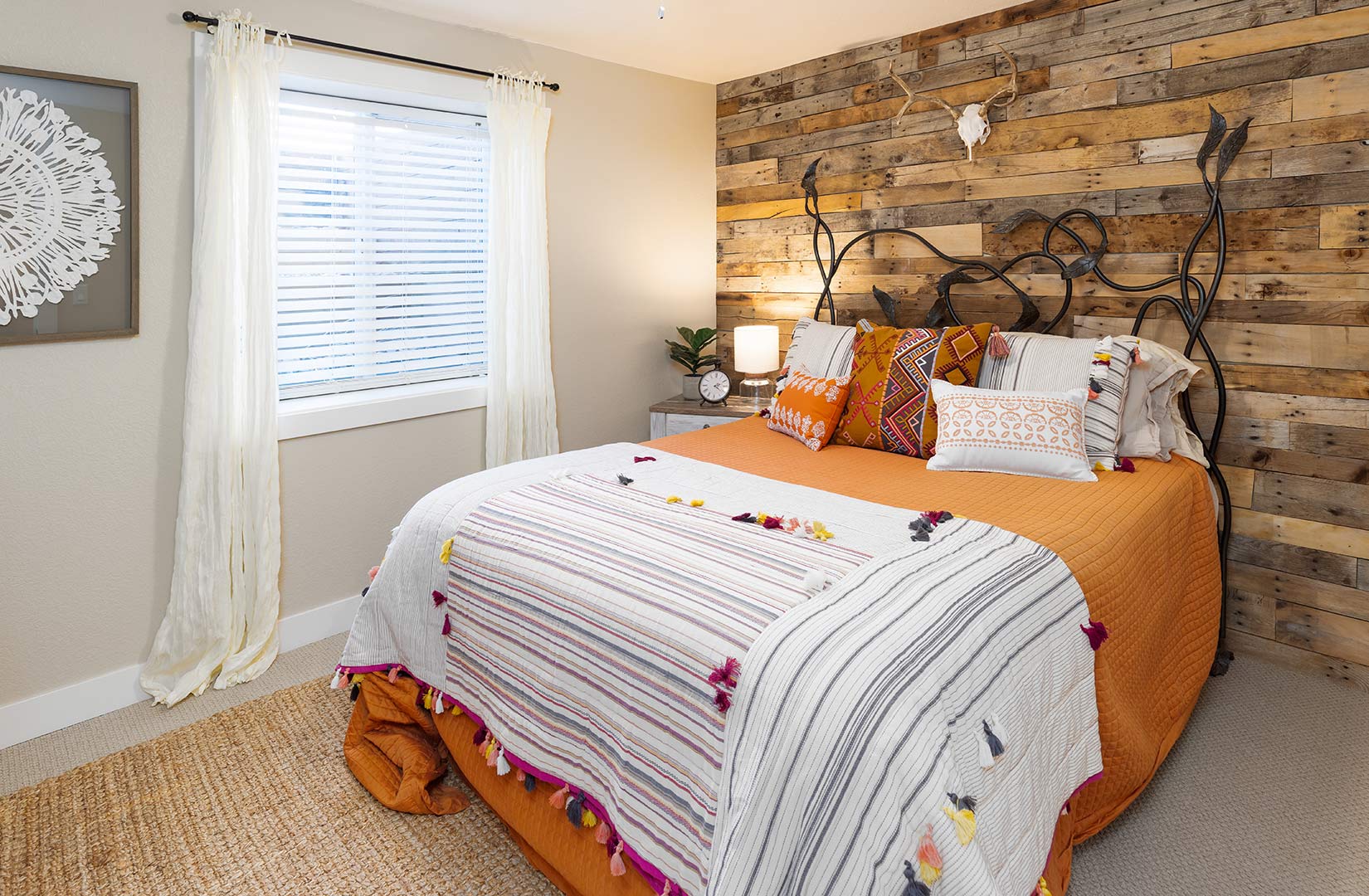 Downstairs bedroom with a barn wood accent wall installed in-house by Freestone Design-Build