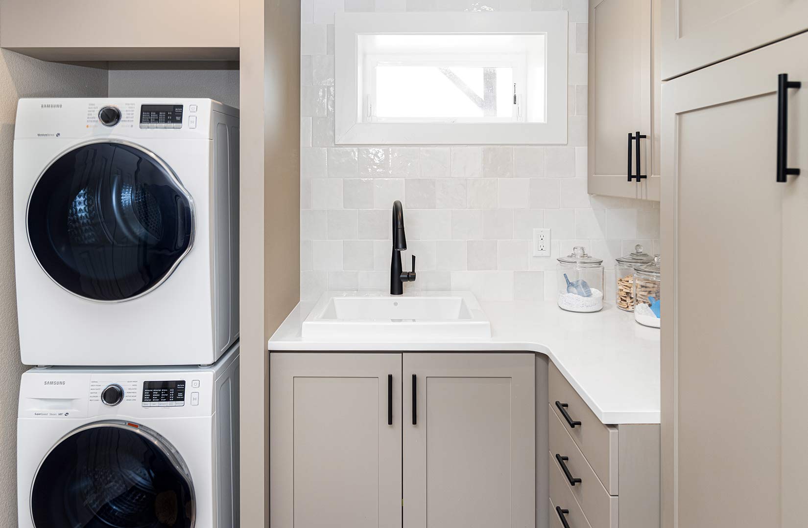Laundry room of Kremmers lane with custom built in shelves, sink and cabinets. 